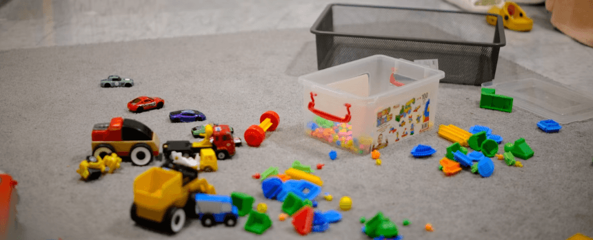 おもちゃで床上がいっぱいのリビングの画像